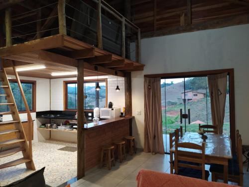 a kitchen and dining room with a loft bed at Rancho dos Mantas in Santo Antônio do Pinhal