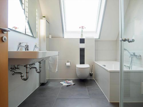 a bathroom with a sink and a toilet and a window at Am Paalen 2 Whg 2 in Zingst