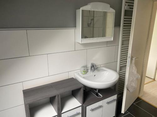 ein Bad mit einem Waschbecken und einem Spiegel in der Unterkunft Haus Aaliyah in Helmstedt