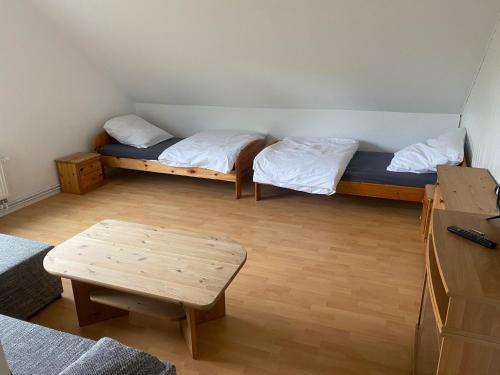 Habitación con 2 camas y mesa. en Haus Aaliyah, en Helmstedt