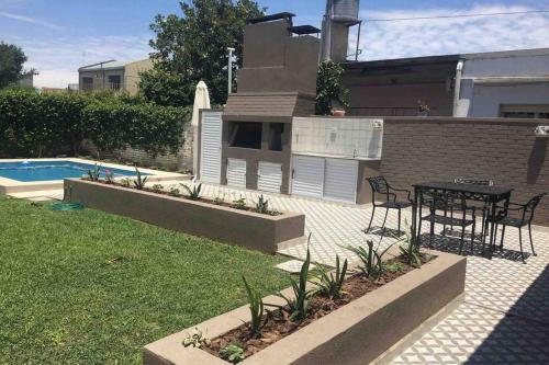 a patio with a table and a grill in a backyard at Ramallo Casa Grande in Ramallo