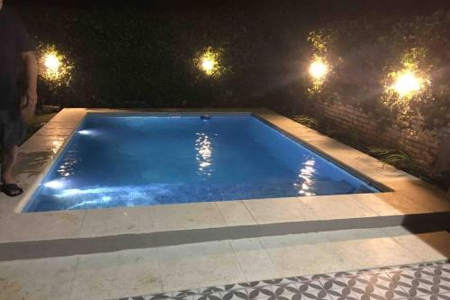 an empty swimming pool at night with lights at Ramallo Casa Grande in Ramallo
