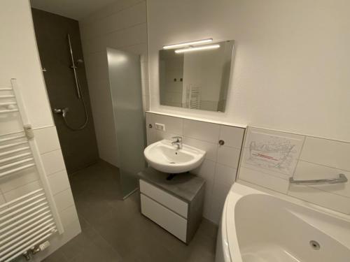 La salle de bains est pourvue d'un lavabo, de toilettes et d'un miroir. dans l'établissement Blackforest Lounge direkt an der Skipiste, inkl Parkplatz und Skiraum, à Feldberg