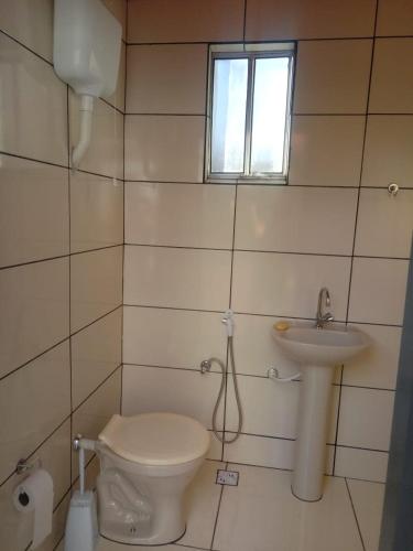 a bathroom with a toilet and a sink at Casa 57 Temporada in Pirenópolis
