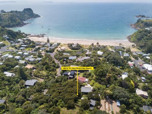 an aerial view of a beach with a yellow sign at Palm Views - Stay Waiheke in Palm Beach