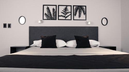 a bedroom with a large bed with black and white pillows at Juana House in San Juan