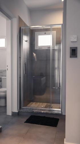 a shower with a glass door in a bathroom at Juana House in San Juan