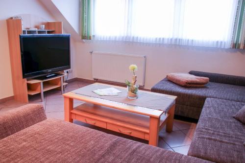 a living room with a tv and a coffee table at Familienhof Brüning - Gartenblick in Meppen