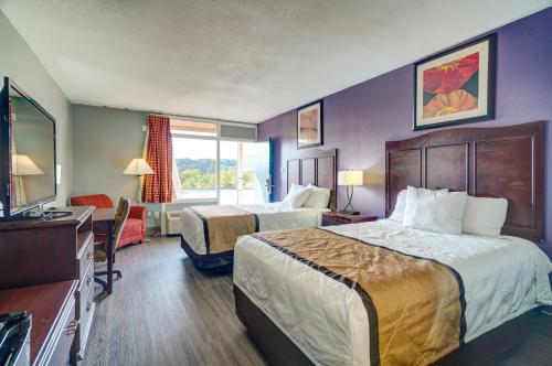 a hotel room with two beds and a television at Budget Inn Top of Ellijay in Ellijay
