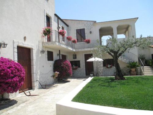 a white house with flowers on the balconies at Le Zarafe in Caltabellotta