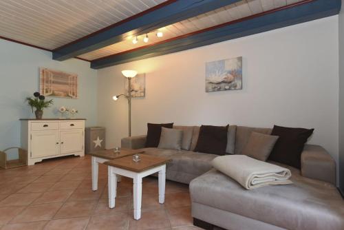ein Wohnzimmer mit einem Sofa und einem Tisch in der Unterkunft Haus Hahnenhof Whg 08 in Wrixum