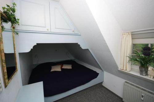 een kleine kamer met een bed op de zolder bij Haus Hahnenhof Whg 08 in Wrixum