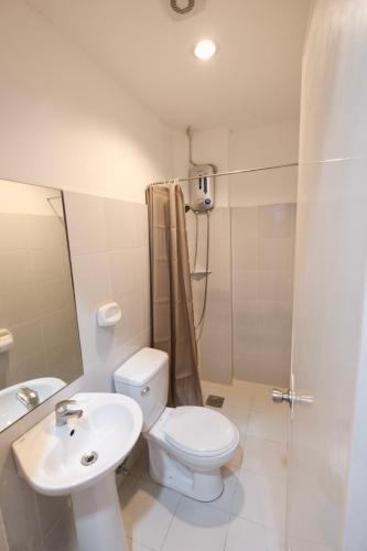 a bathroom with a toilet and a sink and a shower at Beds & Friends Hostel Mactan with Pool and Bar in Mactan
