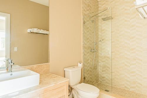 y baño con ducha, aseo y lavamanos. en GORGEOUS - Luxurious 4 bedroom House 10 min drive to Disney World, en Orlando