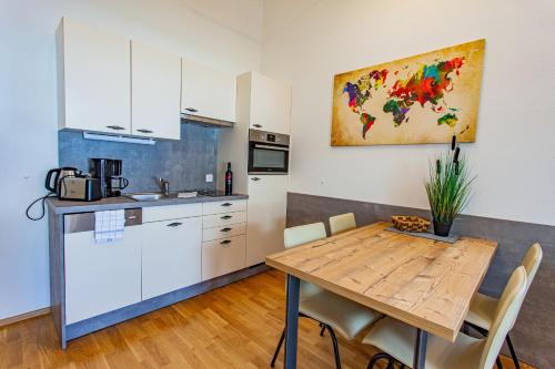 a kitchen and dining room with a wooden table at Happy Aich 3 by Alpenidyll Apartments in Aich
