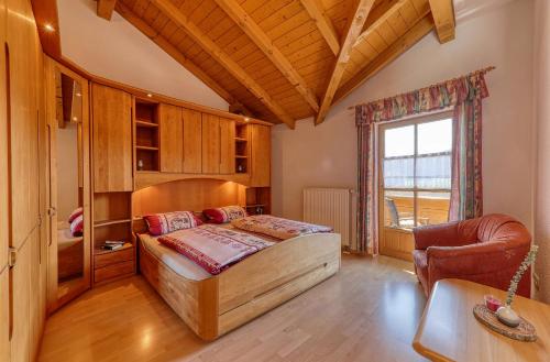1 dormitorio con 1 cama y 1 silla en una habitación en Ferienwohnung "Familienglück" en Achslach