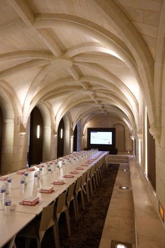 a large room with a long table in a building at Fontevraud L'Ermitage in Fontevraud-l'Abbaye