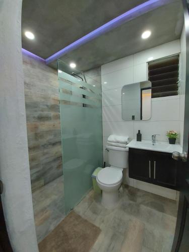 uma casa de banho com um WC, um lavatório e um espelho. em Cómodo Apto de 2hab con Aire 2baños, cerca de todo en Alma Rosa I em El Seis