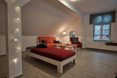 a bedroom with a bed and a couch and a table at Ferienwohnung im Pfarrhaus Kölzow in Kölzow