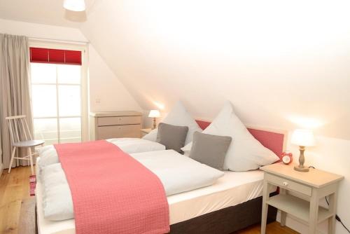 ヴィーク・アウフ・フェールにあるHaus Lachmöwe Waldstraßeのベッドルーム1室(白いベッド1台、赤い毛布付)
