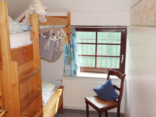 a bedroom with a bunk bed and a chair and a window at Scheideheck in Hasselberg