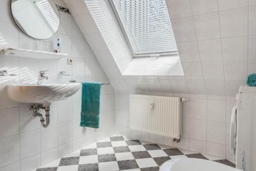 a white bathroom with a sink and a mirror at Friedenstraße 21 Whg 5 in Zingst