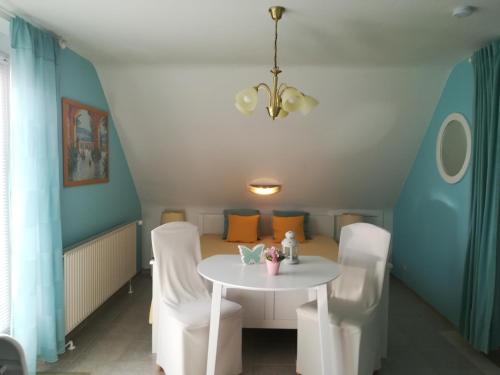 a dining room with a white table and white chairs at Ferienwohnung Schmetterling II in Großenbrode
