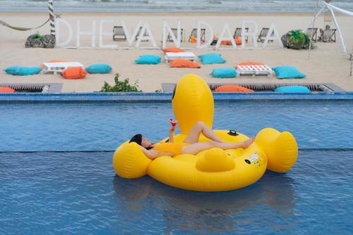 a woman is laying on an inflatable at Dhevan Dara Beach Villa Kuiburi in Kui Buri