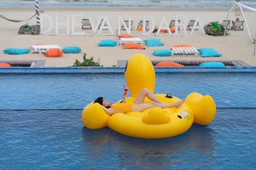 a woman is laying on an inflatable at Dhevan Dara Beach Villa Kuiburi in Kui Buri