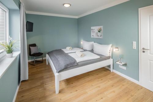 um quarto com uma cama com paredes azuis em Ferienhaus Seeblick - 78913 em Gammendorf