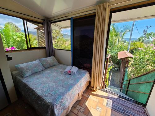 a bedroom with a bed and a large window at Jaco Surf Beachbungalow in Jacó