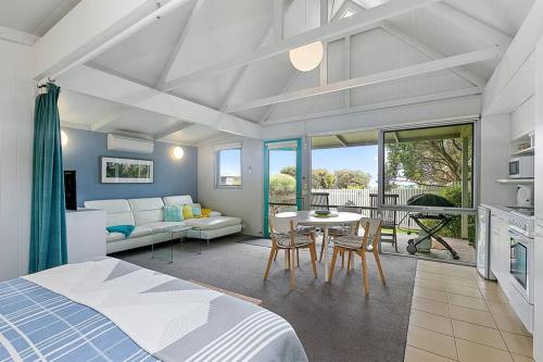 a bedroom with a bed and a table and chairs at The Bay Beach Studio ~ Ocean View in Apollo Bay