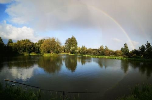 un arco iris sobre un gran estanque con un arco iris en zum Zander, en Wester-Ohrstedt