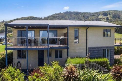 a house with a balcony on the side of it at Beachside Bliss with Secure yard l Pet Friendly in Apollo Bay