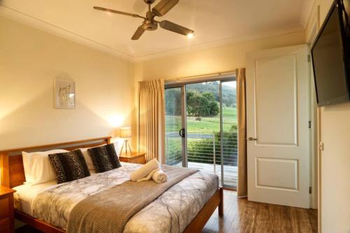 a bedroom with a bed with a ceiling fan at Beachside Bliss with Secure yard l Pet Friendly in Apollo Bay