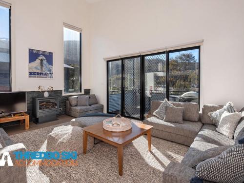 a living room with a couch and a table at Blues Air 4 in Thredbo