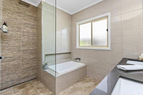 a bathroom with a bath tub and a sink at The Landcastle ~Family Holiday Home~Corporate Wifi in Apollo Bay