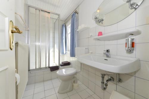 Baño blanco con lavabo y aseo en Pension Hilligenlei Zi 08 DZ, en Wyk auf Föhr