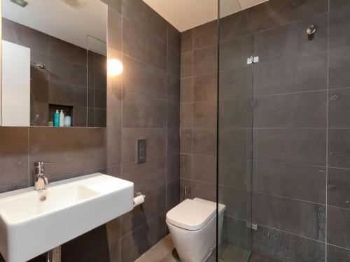 a bathroom with a sink and a toilet and a mirror at Cedar Creek 3 in Thredbo