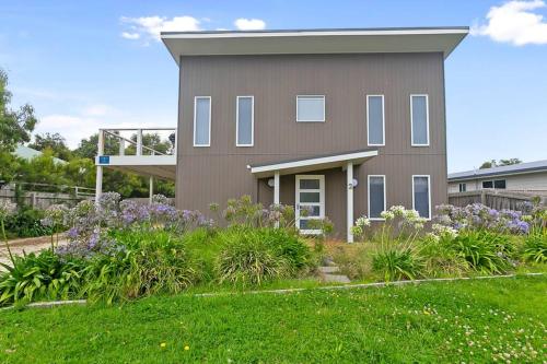 a house with a garden in front of it at Charlie’s Beach House 1Block to Beach Pet Friendly in Apollo Bay