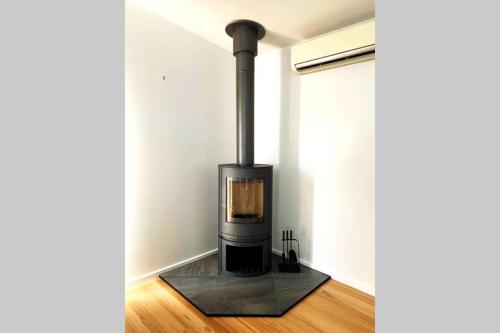 a black stove sitting in a room at Charlie’s Beach House 1Block to Beach Pet Friendly in Apollo Bay