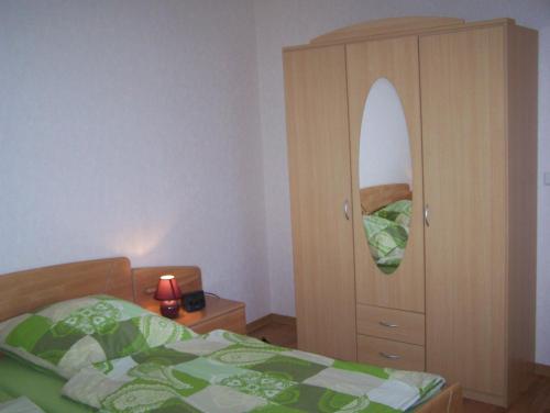 um quarto com uma cama e uma cómoda com um espelho em Ferienwohnung Mauer, Wohnung "Ost" em Heede