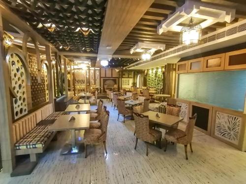 a restaurant with tables and chairs in a room at Ghar 365 Residency in Guwahati