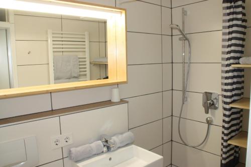 a bathroom with a sink and a mirror and a shower at Fewo Nachbaur Typ A1 in Oberjoch