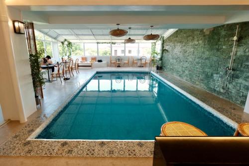 an indoor pool with blue water in a house at Beds & Friends Hostel Mactan with Pool and Bar in Mactan