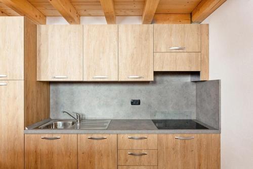a kitchen with a sink and wooden cabinets at Gressoney Saint-Jean apartments by Halldis in Gressoney-Saint-Jean