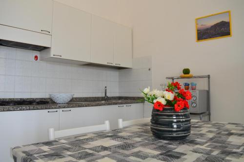 a kitchen with a vase with flowers on a table at Le Zagare Case Vacanza in Cropani