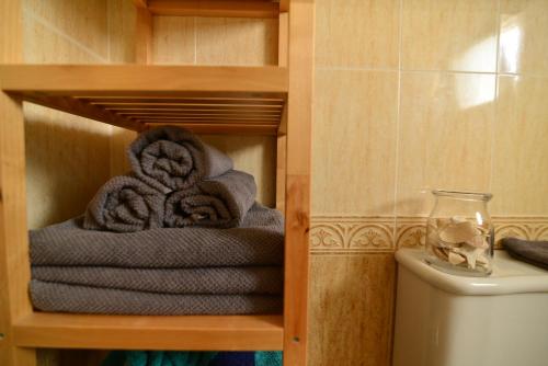 una pila di asciugamani su uno scaffale in un bagno di Villa Isabelita a Torremolinos