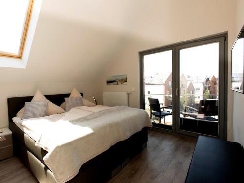 a bedroom with a large bed and a large window at Ostsee - Appartement Nr 50 "Meerblick" am Yachthafen im Strand Resort in Heiligenhafen