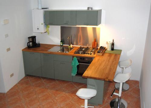 cocina con armarios verdes y fogones horno superior en da Susanna en Perticara